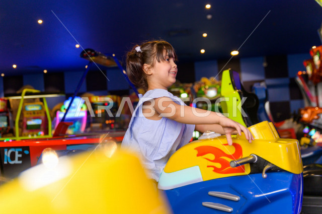 طفلة سعودية في مدينة الألعاب ، تلعب العديد من الألعاب الالكترونية المتنوعة  ، قضاء اوقات رائعة في مدينة الملاهي ، العاب الكترونية ، التسلية و الترفيه ، الترفيه في العطلة الصيفية