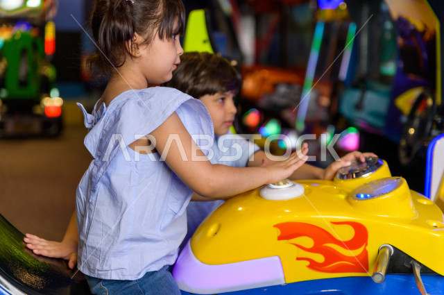طفلان سعوديان في مدينة الألعاب ، يلعبان العديد من الألعاب الالكترونية المتنوعة و المسلية ، قضاء اوقات رائعة في مدينة الملاهي ، العاب الكترونية ، التسلية و الترفيه ، الترفيه في العطلة الصيفية