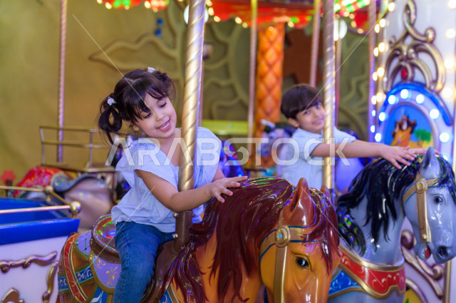 طفلان سعوديان في مدينة الألعاب ، يلعبان العديد من الألعاب الالكترونية المتنوعة و المسلية ، قضاء اوقات رائعة في مدينة الملاهي ، العاب الكترونية ، التسلية و الترفيه ، الترفيه في العطلة الصيفية