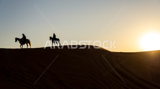 ذكرى تأسيس الدولة السعودية الأولى 22 فبراير، أنشطة وفعاليات سباق الجياد العربية في الصحراء، صورة ظلية لفارسين عربيين خليجيين سعوديين يمتطيان الخيول يتجولان فوق الرمال الذهبية في النهار، يوم بدينا 1727 م، توارث حب وتربية الحصان العربي من الأجداد، سالوييت