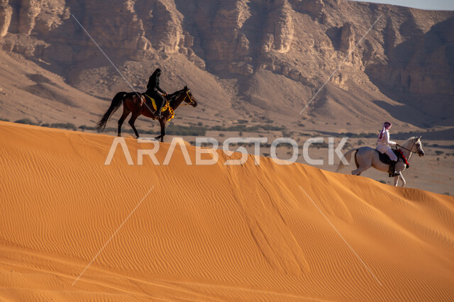 التشكيلات الجبلية والصخرية، شغف السعوديين بتربية الخيول، الاستمتاع بالتجول في الصحراء على ظهر الحصان، الفخر بالتراث السعودي، فارس وفارسة عربيان خليجيان سعوديان يمتطيان الجياد العربية الأصيلة، ذكرى تأسيس الدولة السعودية الأولى في 22 فبرير، يوم بدينا 1727م