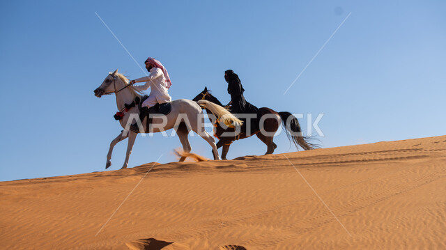 الاستمتاع بالتجول في الصحراء على ظهر الحصان، ممارسة الأنشطة الترفيهية فوق الرمال الذهبية الناعمة، الفخر بالتراث السعودي، فارس وفارسة عربيان خليجيان سعوديان يمتطيان الجياد العربية الأصيلة، ذكرى تأسيس الدولة السعودية الأولى في 22 فبرير، يوم بدينا 1727م