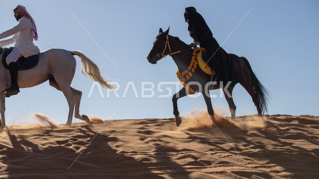 ممارسة الأنشطة الترفيهية فوق الرمال الذهبية الناعمة، الفخر بالتراث السعودي، زوجان عربيان خليجيان سعوديان يمتطيان الجياد العربية الأصيلة، ذكرى تأسيس الدولة السعودية الأولى في 22 فبرير، التجول في الصحراء على ظهر الحصان، يوم بدينا 1727م