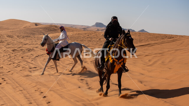 ممارسة الأنشطة الترفيهية فوق الرمال الذهبية الناعمة، الفخر بالتراث السعودي، زوجان عربيان خليجيان سعوديان يمتطيان الجياد العربية الأصيلة، ذكرى تأسيس الدولة السعودية الأولى في 22 فبرير، التجول في الصحراء على ظهر الحصان، يوم بدينا 1727م