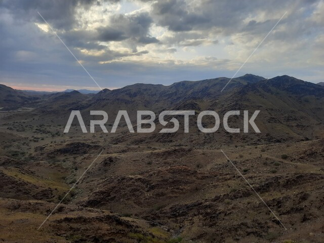 View of the cloudy sky in the winter in the Al-Baha region, terrain, peaks and mountain heights in the city of Al-Hujra, natural tourist places and areas in the cities of the Kingdom of Saudi Arabia, nature background