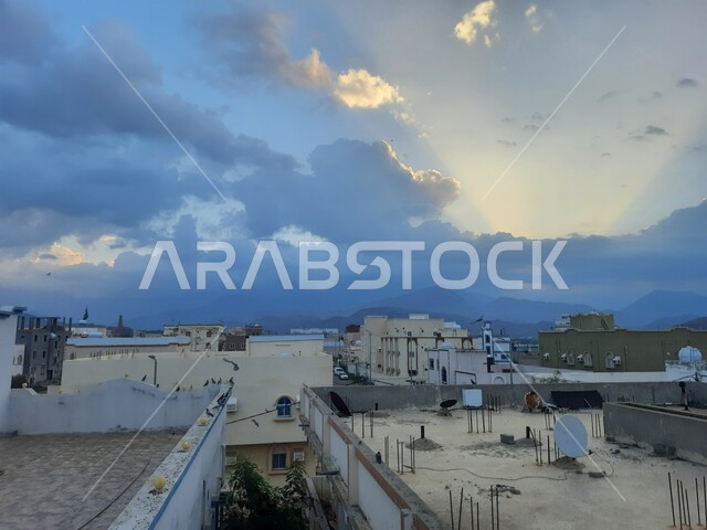 فن العمارة القديمة للمباني والمنشآت السكنية في قرى المملكة العربية السعودية, منظر السماء المليئة بالغيوم والسحب في النهار في منطقة الباحة ، صورة من الاعلى لأسطح المنازل والبيوت في مدينة الحجرة
