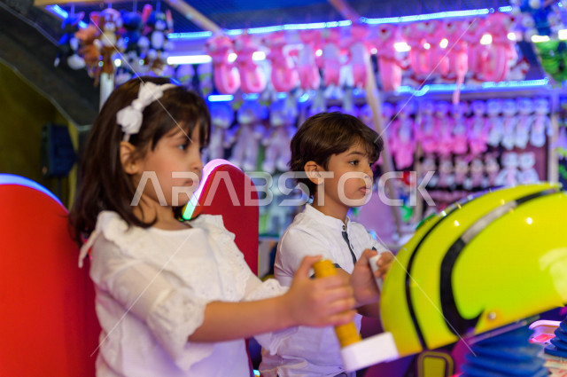  طفلان سعوديان في مدينة الألعاب ، يلعبان العديد من الألعاب الالكترونية المتنوعة و المسلية  ، قضاء اوقات رائعة في مدينة الملاهي ، العاب الكترونية ، التسلية و الترفيه ، الترفيه في العطلة الصيفية