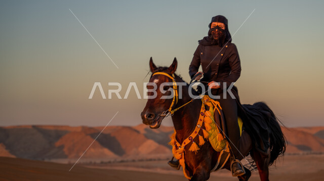 التشكيلات الجبلية والصخرية، التجول على ظهر الفرس في الصحراء فوق الرمال الذهبية, اتباع تقاليد الأجداد في حب وتربية الجياد, فارسة عربية خليجية سعودية ترتدي البرقع والعباءة تمتطي حصان بني أصيل, يوم بدينا 1727 م, ذكرى تأسيس الدولة السعودية الأولى 22 فبراير
