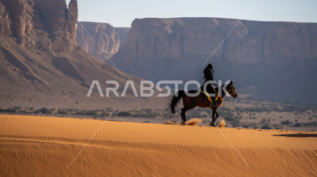 التشكيلات الجبلية والصخرية، التجول على ظهر الفرس في الصحراء فوق الرمال الذهبية, اتباع تقاليد الأجداد في حب وتربية الجياد, فارسة عربية خليجية سعودية ترتدي البرقع والعباءة تمتطي حصان بني أصيل, يوم بدينا 1727 م, ذكرى تأسيس الدولة السعودية الأولى 22 فبراير
