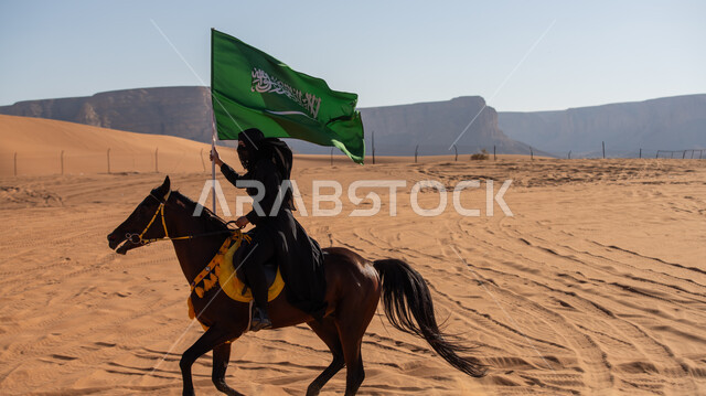  إحياء التراث السعودي التقليدي الشعبي، رفع علم المملكة في اليوم الوطني في 23 سبتمبر, يوم بدينا 1727م, ذكرى تأسيس الدولة السعودية الأوى في 22 فبراير, فارسة عربية خليجية سعودية ترتدي العباءة السوداء تمتطي فرس بني أصيل, يوم العلم 11 مارس