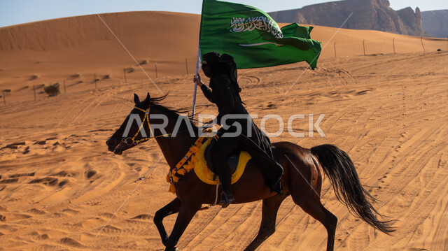 احتراف هواية الفروسية، إحياء التراث السعودي التقليدي الشعبي، رفع علم المملكة في يوم بدينا 1727م, ذكرى تأسيس الدولة السعودية الأوى في 22 فبراير, فارسة عربية خليجية سعودية ترتدي العباءة السوداء والبرقع تمتطي فرس بني أصيل, يوم العلم 11 مارس
