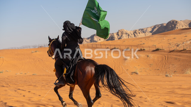احتراف هواية الفروسية، إحياء التراث السعودي التقليدي الشعبي، رفع علم المملكة في يوم بدينا 1727م, ذكرى تأسيس الدولة السعودية الأوى في 22 فبراير, فارسة عربية خليجية سعودية ترتدي العباءة السوداء والبرقع تمتطي فرس بني أصيل, يوم العلم 11 مارس