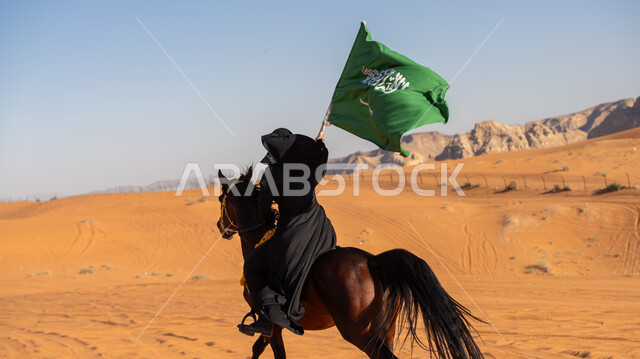  إحياء التراث السعودي التقليدي الشعبي، رفع علم المملكة في اليوم الوطني في 23 سبتمبر, يوم بدينا 1727م, ذكرى تأسيس الدولة السعودية الأوى في 22 فبراير, فارسة عربية خليجية سعودية ترتدي العباءة السوداء تمتطي فرس بني أصيل, يوم العلم 11 مارس