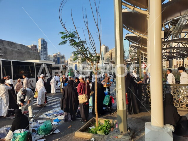 وسائل النقل والمواصلات, السياحة الدينية في السعودية, مقصد المسلمين من كل انحاء العالم لأداء العبادات والتقرب الى الله, اماكن ومعالم دينية اسلامية مقدسة في المملكة, مجموعة من زوار بيت الله الحرام في موقف كدي للحافلات بجوار الحرم المكي بمكة المكرمة