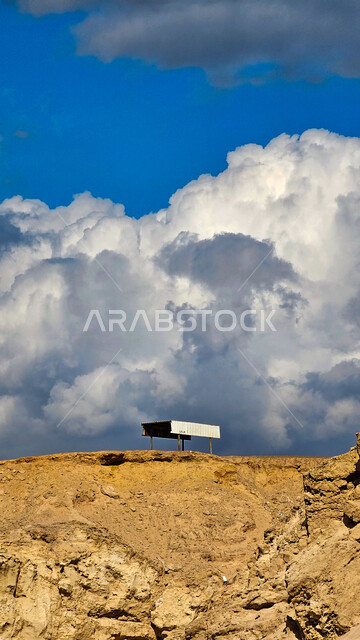 منظر الغيوم المتكاثفة في سماء مدينة حقل في المملكة العربية السعودية، السحب السوداء الملبدة، سلسلة الجبال و التشكيلات و التكوينات الحجرية، المساحات الصخرية الواسعة