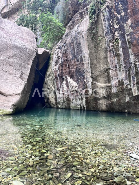 القمم والتكوينات الصخرية في الأودية، نمو الاشجار والنباتات الخضراء، مناطق وأماكن طبيعية سياحية في المملكة العربية السعودية، وادي لجب في جبل القهر بمدينة جازان، المياه الزرقاء والمسطحات المائية بين صدع جبلي