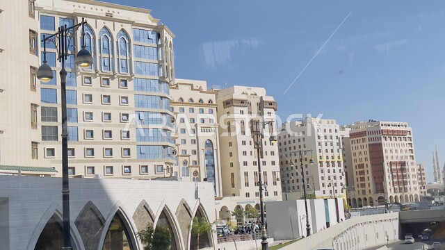 مفهوم النمو والتطور العمراني, المباني والفنادق الفاخرة في جوار المسجد النبوي الشريف في وقت النهار، الفن الهندسي المعماري على الطراز الحديث للأبراج في المدينة المنورة،  معالم واماكن اسلامية دينية مقدسة في المملكة العربية السعودية