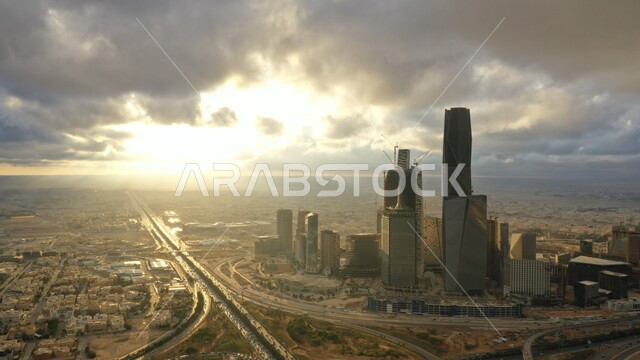 Lifestyle in the country, development and urban progress in the capital, aerial photo of the city of Riyadh at sunset, roads and streets in the Kingdom of Saudi Arabia, interest in planting trees and green plants in cities, King Abdullah Financial Center (KAFD), sky full of clouds