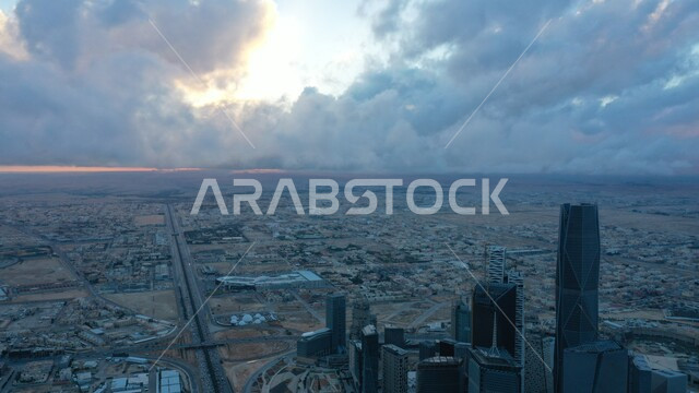 النمو والتقدم العمراني على الطراز الحديث، المعالم والمدن المشهورة، الأبراج وناطحات السحاب المالية والاقتصادية والمنشأت المعمارية وسط السماء المليئة بالغيوم، مركز الملك عبدالله المالي(كافد) في العاصمة، حركة المرور في شوارع مدينة الرياض
