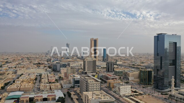 Skyscrapers, towers and architectural achievements, national development engineering projects, famous landmarks and places of Riyadh, urban growth to stimulate tourism in Saudi Arabia, achieving economic and commercial renaissance, the view of the sky filled with white clouds.