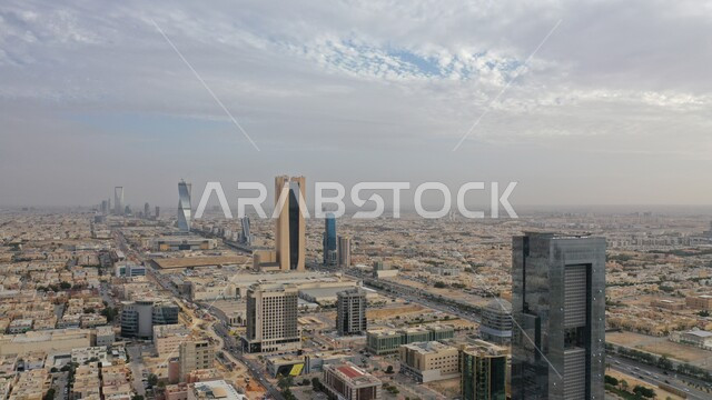 Skyscrapers, towers and architectural achievements, national development engineering projects, famous landmarks and places of Riyadh, urban growth to stimulate tourism in Saudi Arabia, achieving economic and commercial renaissance, the view of the sky filled with white clouds.