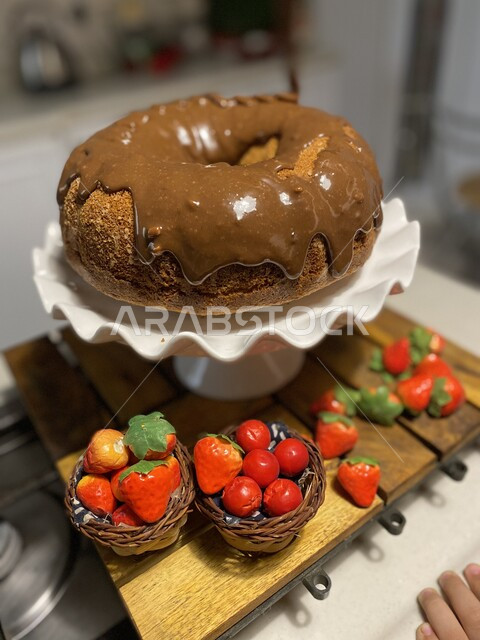 كعكة الحلوى الشهية الغنية والمزينة بالسوكولا السائلة,  تجهيز قالب الكيك الهش واللذيذ للتزيين بالفراولة، مأكولات مليئة بالسكريات والسعرات الحرارية، حلويات طازجة مخبوزة في الفرن