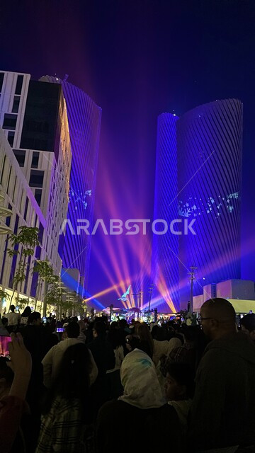 فعاليات ومهرجانات في دولة قطر، صورة من الخلف لمجموعة من السياح يقومو بتصوير الأضواء والاحتفالات من خلال الهواتف المحمولة، الفن الهندسي المعماري للأبراج وناطحات السحاب المشهورة