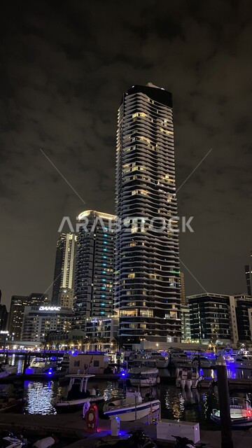 مرفأ ومرسى اليخوت في مارينا دبي في المساء, الفن الهندسي المعماري للمباني والمنشآت المطلة على البحر الإصطناعي، النمو والتطور العمراني للأبراج وناطحات السحاب في دولة الإمارات العربية المتحدة، معالم إمارة دبي السياحية المشهورة, الواجهة البحرية على ساحل الخليج العربي