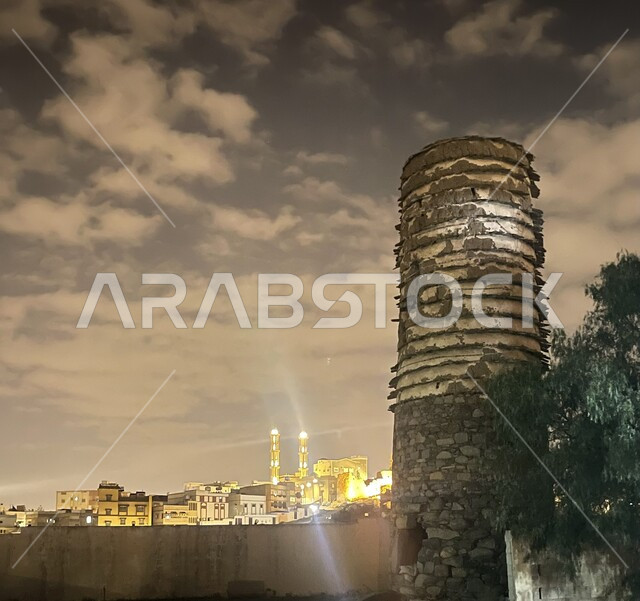 الفن  الهندسي المعماري للمباني السكنية والمنشآت المضيئة في منطقة عسير في المملكة العربية السعودية, برج المراقبة التاريخي الأثري المبني على الطراز الحجري القديم في مدينة ابها، السماء المليئة بالغيوم، النبات والأشجار الخضراء, خلفية طبيعة