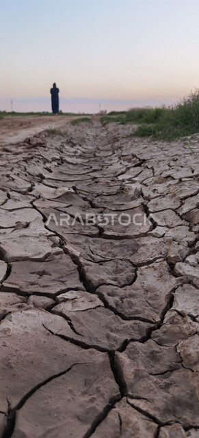 صورة مقربة لأرض طينية متشققة في موسم الجفاف، البيئة الصحراوية القاحلة في مدينة تبوك، مفهوم الإحتباس الحراري، تائج الكوارث الطبيعية والهزات الأرضية، خلفية الطبيعة
