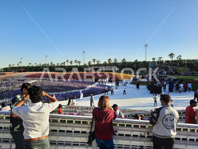 تجمع الزوار والسائحين على المدرجات لحضور فعاليات مهرجان الزهور والحدائق، وجهه عائلية بيئية ثقافية وترفيهية، الحفاظ على البيئة والتنمية المستدامة، معارض ومهرجانات طبيعية سياحية في المملكة العربية السعودية، الديكورات والتصاميم في حديقة المناسبات بمدينة ينبع الصناعية