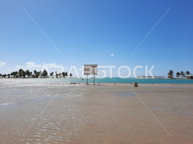 لافتات التنبيه والتحذير على شاطئ الهيئة الملكية في منطقة الجار في النهار، زراعة أشجار النخيل والنباتات الخضراء في المدن السياحية، مناطق وأماكن طبيعية عائليه ترفيهيه على ساحل البحر الاحمر، السواحل الشاطئية والواجهة البحرية في مدينة ينبع في المملكة العربية السعودية