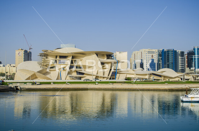 الواجهه البحرية لبحر العرب في النهار، الفن الهندسي المعماري المتطور بتصاميم تعكس الثقافة القطرية وهوية البلاد، المتاحف والمعالم التراثية الحضارية المشهورة في دولة قطر، مبنى المتحف الوطني على شكل وردة الصحراء المطل على كورنيش مدينة الدوحة