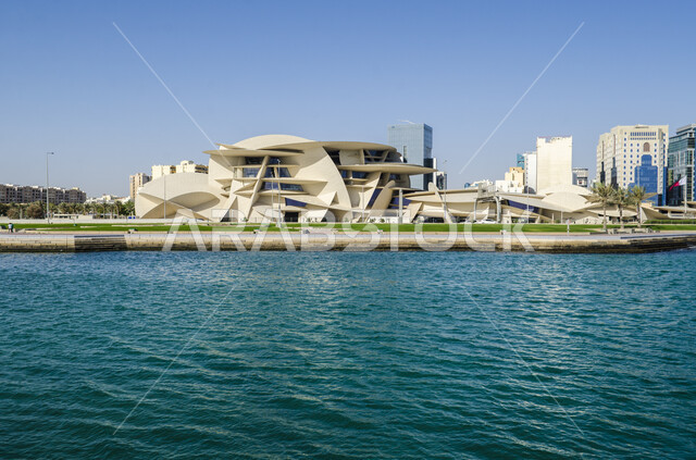 الواجهه البحرية لبحر العرب في النهار، الفن الهندسي المعماري المتطور بتصاميم تعكس الثقافة القطرية وهوية البلاد، المتاحف والمعالم التراثية الحضارية المشهورة في دولة قطر، مبنى المتحف الوطني على شكل وردة الصحراء المطل على كورنيش مدينة الدوحة