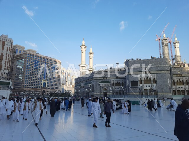 مدن واماكن مقدسة، الفن الهندسي المعماري على الطراز الإسلامي، أداء مناسك الحج والعمرة، الحجاج والمعتمرين في ساحة المسجد الحرام في مكة المكرمة في المملكة العربية السعودية في النهار، الحرم المكي الشريف، معالم دينية إسلامية
