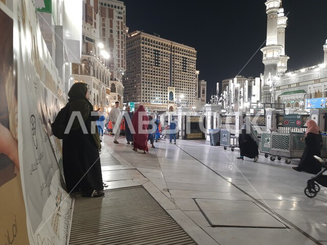 Architectural engineering art in the Islamic style, Islamic religious landmarks, performing Hajj and Umrah rituals, the Holy Mosque of Mecca, a close-up of pilgrims and pilgrims in the courtyard of the Grand Mosque in Mecca in the Kingdom of Saudi Arabia at night, cities and holy places