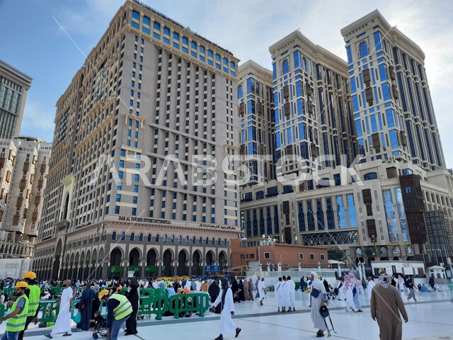 The architectural engineering art of hotels and towers overlooking the Grand Mosque in the Kingdom of Saudi Arabia, sacred Islamic religious places and landmarks, the blue sky scene over the courtyard of the Grand Mosque in Mecca.