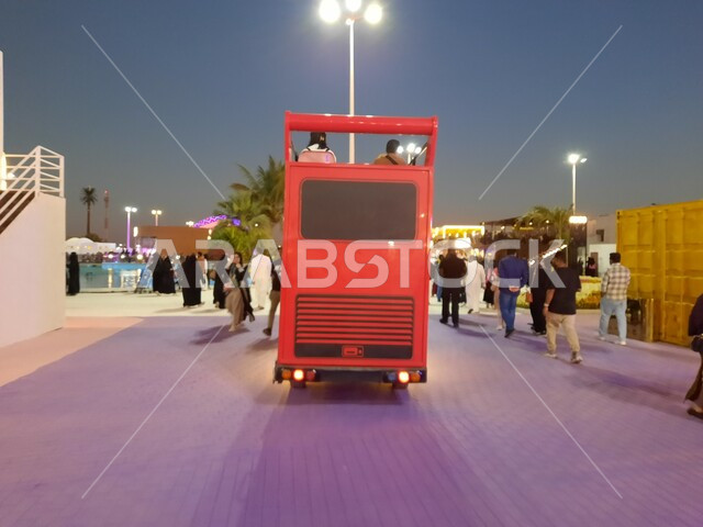 صورة مقربة من الخلف لحافلة مخصصة لنقل زوار مهرجان الزهور، وجهه عائلية ثقافية وترفيهية، معارض طبيعية سياحية في المملكة العربية السعودية، الديكورات والتصاميم في حديقة المناسبات بمدينة ينبع الصناعية