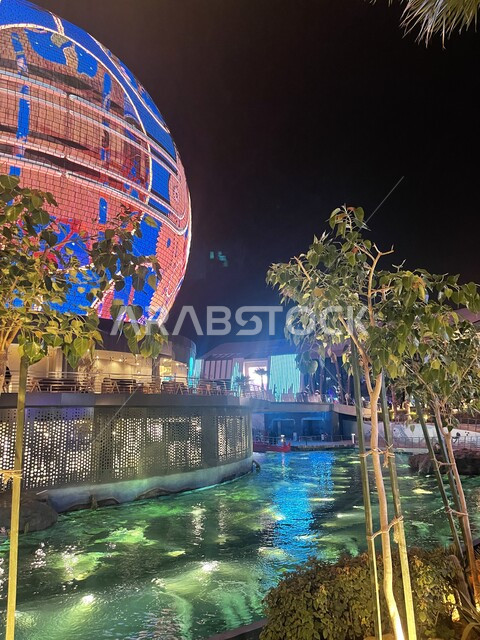 زراعة الاشجار والنباتات الخضراء في المدن السياحية، صورة مقربه للبحيرة الصناعيه في البوليفارد وورلد في مدينه الرياض, أنشطة ترفيهيه عائليه ممتعه, منتزهات وأماكن مشهورة في المملكه العربيه السعوديه، فعاليه الكره العملاقه المضيئة في وقت الليل