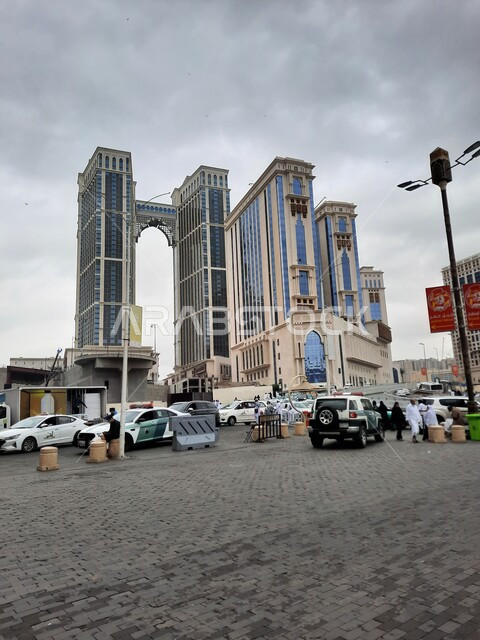 الأجواء الشتوية الغائمة والسماء المليئة بالغيوم فوق مجمع جبل عمر في مكة المكرمة، فنادق ومنتجعات كونراد الفاخرة بالسعودية، مواقف خاصة للسيارات في شارع إبراهيم الخليل، الفن الهندسي المعماري المتطور للأبراج والمباني السياحية