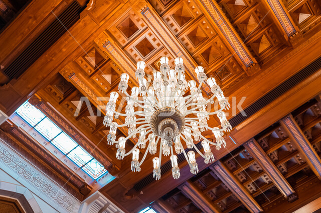 Huge and luxurious antiques and chandeliers inside the Sultan Qaboos Grand Mosque in Muscat, famous sacred religious Islamic places and landmarks in the Sultanate of Oman, worship and getting closer to God, performing religious duties, modern Islamic architectural art.