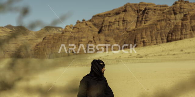 معالم اثرية تاريخية, التكوينات والتشكيلات الصخرية في المناطق الصحراوية, صورة من الجانب لرجل عربي سعودي خليجي  يرتدي زي يوم التأسيس يتجول في  محافظة العلا في المملكة العربية السعودية, يوم بدينا 1727م, ذكرى تأسيس الدولة السعودية الأولى في 22 فبراير