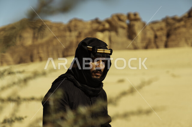 معالم تاريخية أثرية سياحية, التكوينات والتشكيلات الصخرية في المناطق الصحراوية في محافظة العلا في المملكة, ذكرى تأسيس الدولة السعودية الأولى في 22 فبراير, صورة مقربة لرجل عربي سعودي خليجي يرتدي زي يوم التأسيس ينطر إلى الكاميرا, يوم بدينا 1727 م