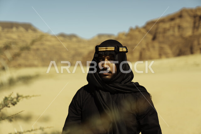 ذكرى تأسيس الدولة السعودية الأولى في 22 فبراير,  يوم بدينا 1727, مناطق المرتفعات الجبلية والتكوينات الصخرية, صورة مقربة لشاب عربي سعودي خليجي يرتدي زي يوم التأسيس يقف في إحدى المناطق الأثرية في محافظة العلا, أماكن سياحية مشهورة في المملكة العربية السعودية