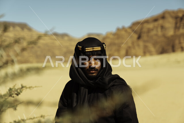 مناطق المرتفعات الجبلية والتكوينات الصخرية, يوم بدينا 1727, صورة مقربة لشاب عربي سعودي خليجي يرتدي زي يوم التأسيس يقف في إحدى المناطق الأثرية في محافظة العلا,  ذكرى تأسيس الدولة السعودية الأولى في 22 فبراير, أماكن سياحية مشهورة في المملكة العربية السعودية