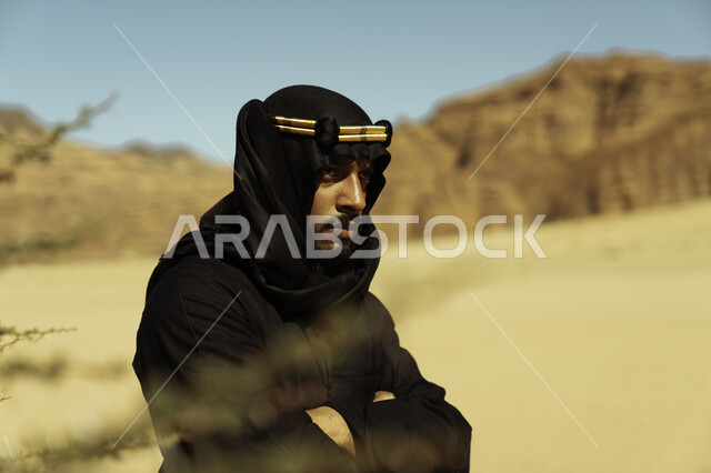 التكوينات والتشكيلات الصخرية في المناطق الصحراوية في محافظة العلا في المملكة, معالم تاريخية أثرية سياحية, صورة مقربة لرجل عربي سعودي خليجي يرتدي زي يوم التأسيس ينطر إلى شيء ما, يوم بدينا 1727 م, ذكرى تأسيس الدولة السعودية الأولى في 22 فبراير