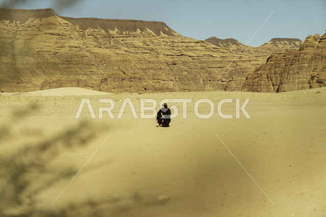 Rock formations and formations in Al-Ula Governorate in the Kingdom of Saudi Arabia, Our Day 1727 AD, the anniversary of the founding of the Saudi state February 22, a Saudi Gulf Arab man wearing a Founding Day costume standing in one of the places in the desert areas, wandering around the archaeological tourist areas