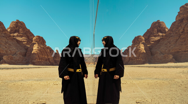  يوم بدينا 1727م, ذكرى تأسيس الدولة السعودية الأولى في 22 فبراير, رجل عربي خليجي سعودي يرتدي زي يوم التأسيس يستمتع في إحدى المناطق والمعالم الأثرية, التكوينات والتشكيلات الصخرية, انعكاس جسم الشاب على مسرح مرايا في محافظة العلا السياحية في السعودية