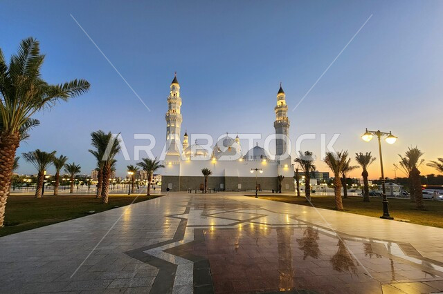 الساحة الخارجية لمسجد قباء في المدينة المنورة وقت الغروب، معالم و أماكن دينية مقدسة في المملكة العربية السعودية، العبادة والتقرب إلى الله، المآذن و القبب المضيئة، الفن الهندسي المعماري والديكورات الاسلامية على الطراز الحديث، الاهتمام بزراعة أشجار النخيل
