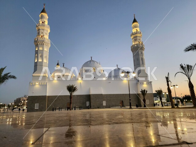 الساحة الخارجية لمسجد قباء في المدينة المنورة وقت الغروب، معالم و أماكن دينية مقدسة في المملكة العربية السعودية، العبادة والتقرب إلى الله، المآذن و القبب المضيئة، الفن الهندسي المعماري والديكورات الاسلامية على الطراز الحديث، الاهتمام بزراعة أشجار النخيل